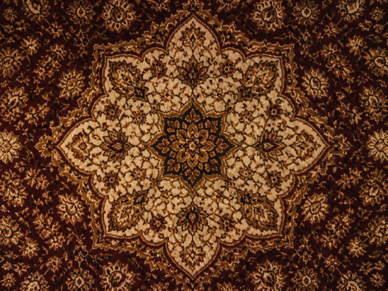 Détail du médaillon central d'un tapis ancien en laine